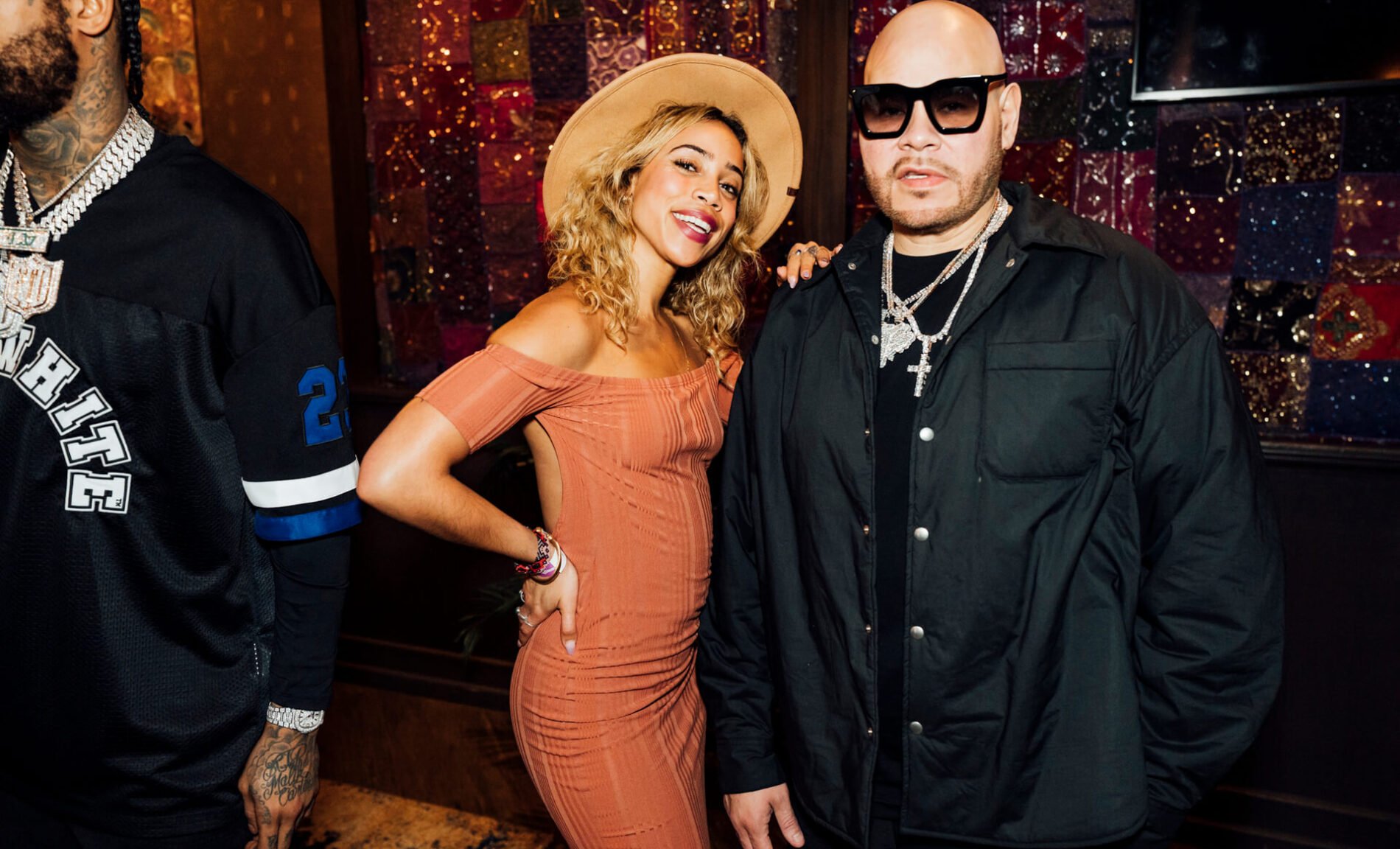 Fat Joe and a stylish attendee posing for a photo at a music festival event, with a colorful and patterned background, organised by emc3, a global events agency