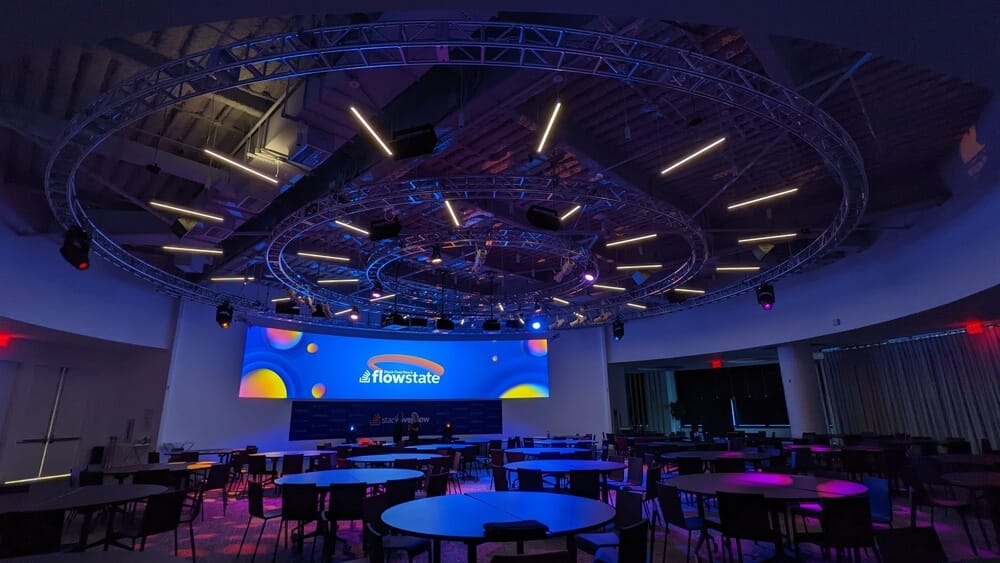 Flowstate event venue setup with ambient lighting and round tables