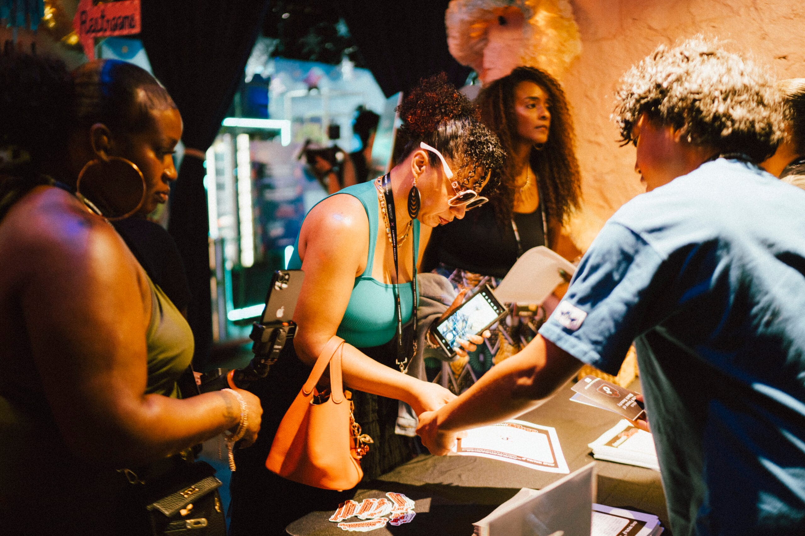A group of three black women are looking at a display on a booth during the TikTok Shop Juneteenth Experience in Atlanta.