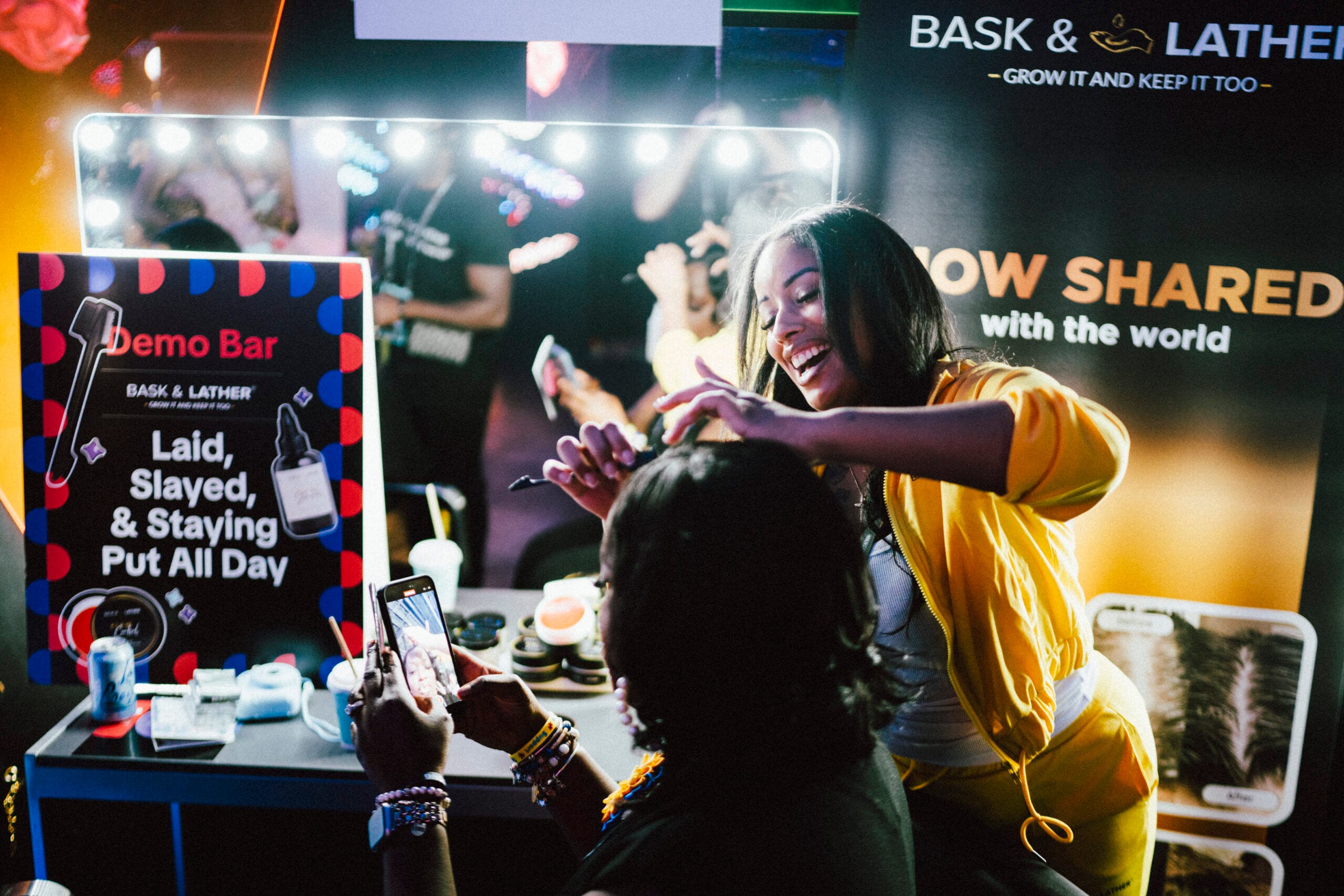 A black female hairstylist is styling a womans hair at a booth during the TikTok Shop Juneteenth Experience in Atlanta.